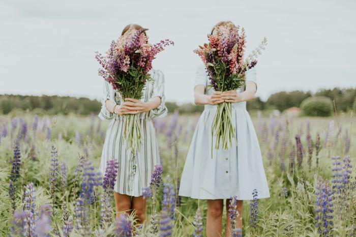 Two guests holding fresh-cut flowers, the feeling a Serenity Spa gift card is meant to give